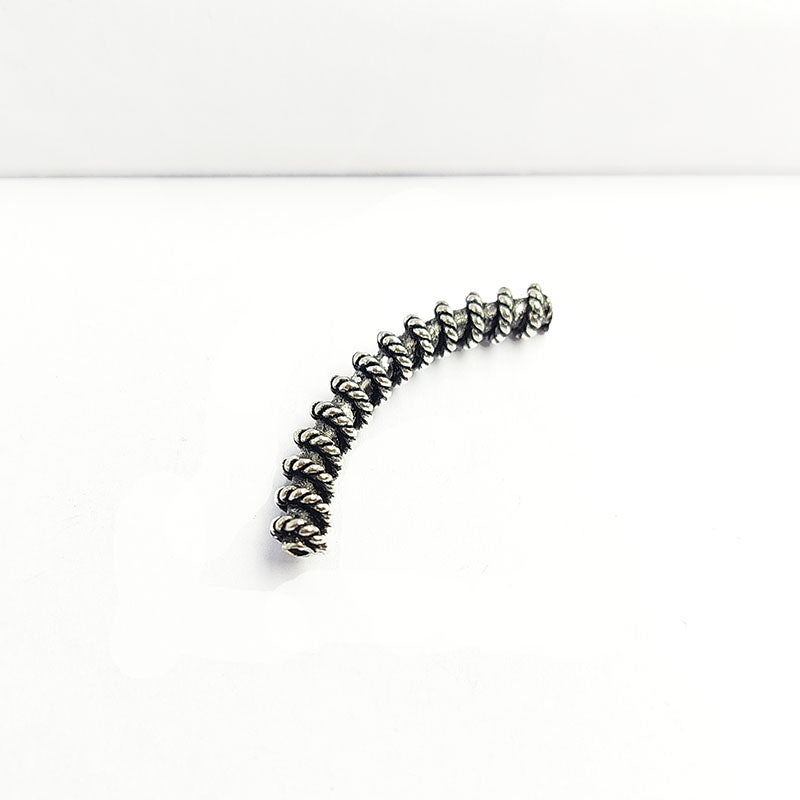 Handcrafted twisted silver overlay over copper tube Bali charm from India with oxidized detailing and curved design