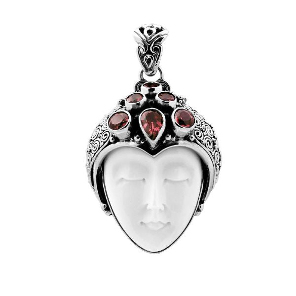 Handcrafted sterling silver pendant featuring a serene goddess face carved from bone with sparkling garnet gemstones, unique Balinese artisan jewelry for women.