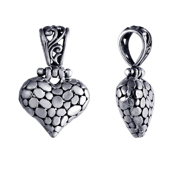 Handcrafted sterling silver heart pendant with textured detailing and ornate Balinese design, a timeless symbol of love and artisan jewelry for women.