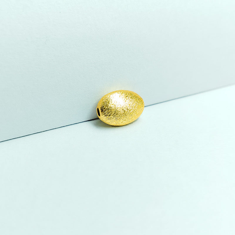 Smooth oval barrel jewelry bead with 18K gold overlay over copper handcrafted in India